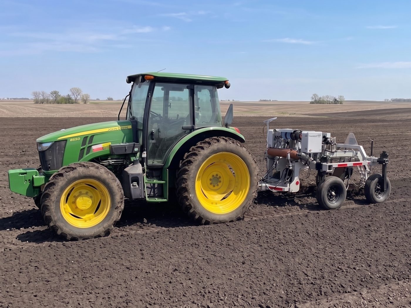 Blaster 1000 towed behind a tractor in a field, real unit in the field